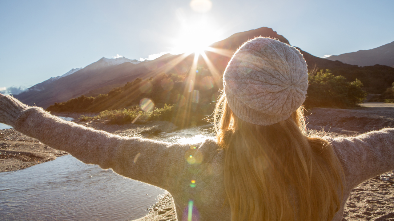 Frau vor Berglandschaft bei Sonnenaufgang